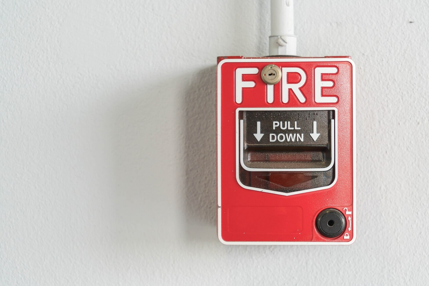 Fire alarm pull station on school wall